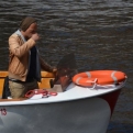 A laid back boat tour guide, drinking coffee whilst manoeuvring